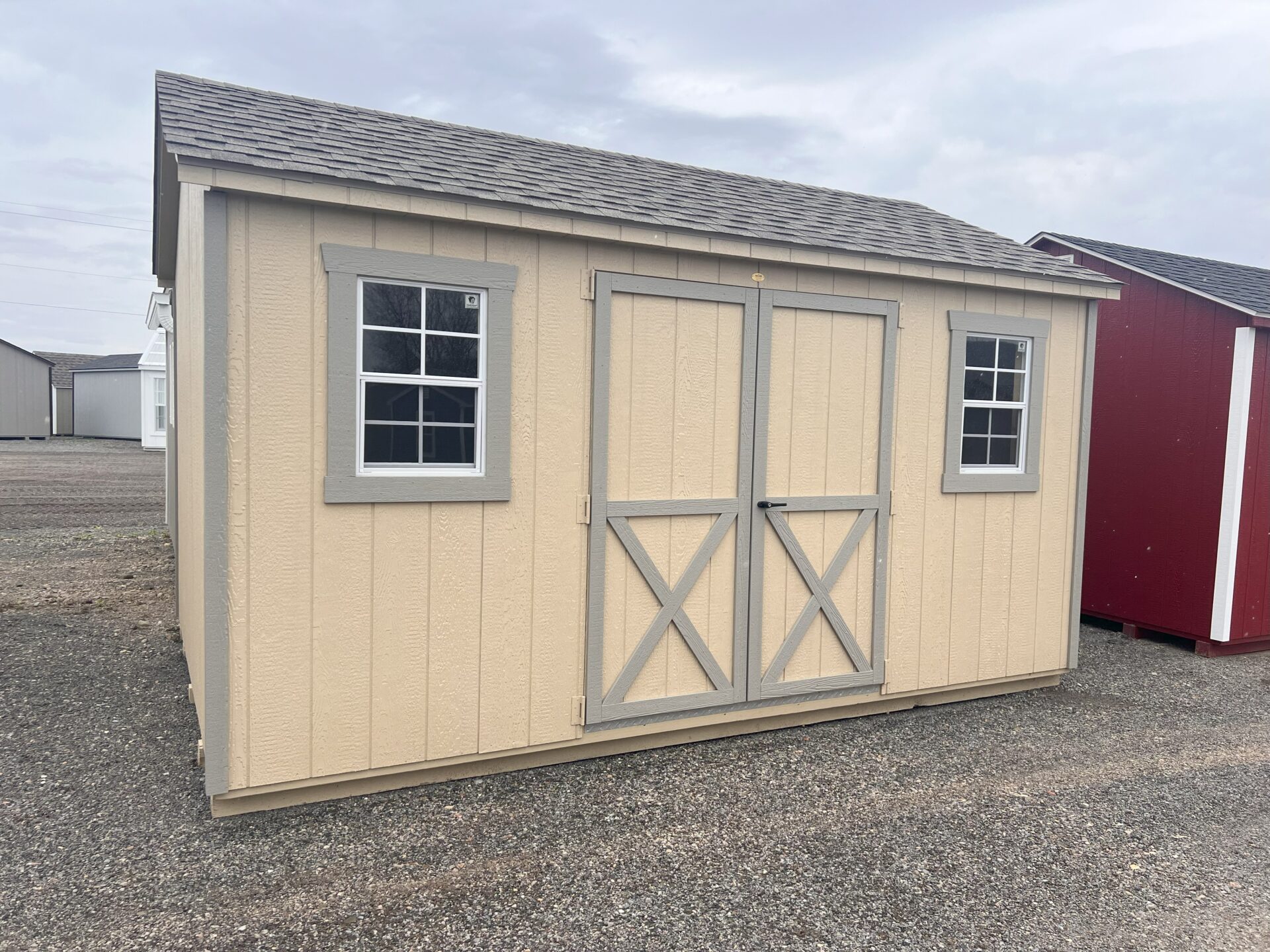 Tan shed with double doors and two windows
