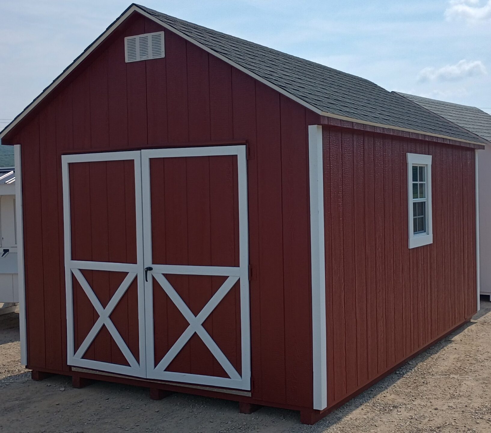 Red shed with white trim, oversized double doors, 2 windows and shingled roof