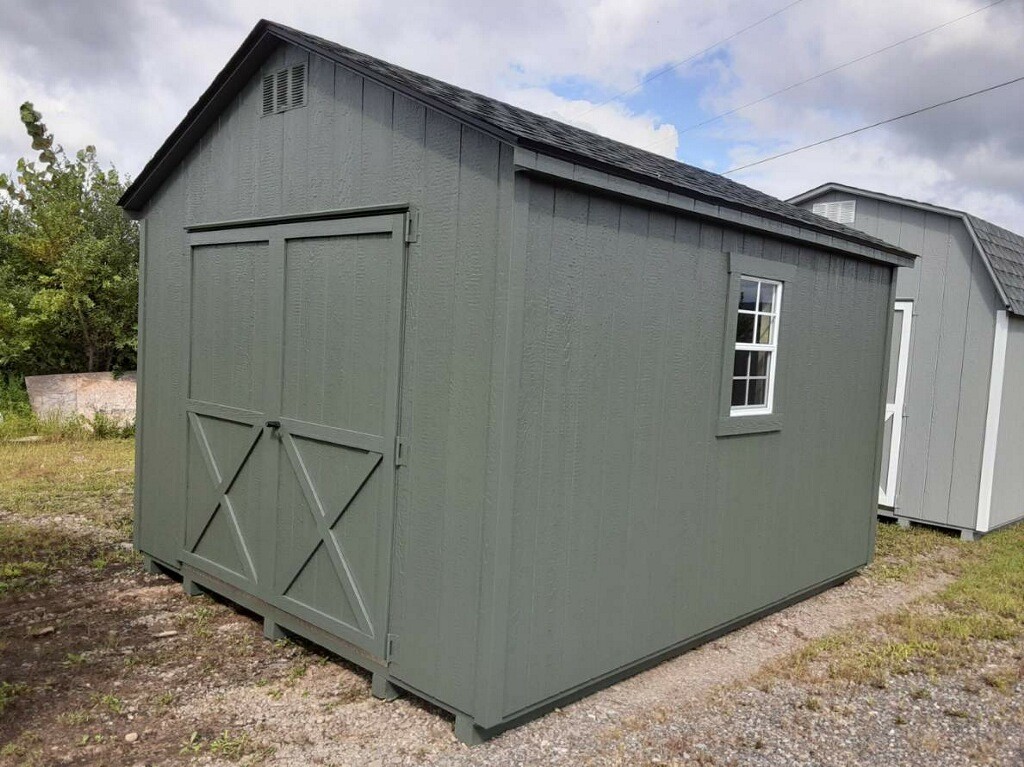 Green shed with double doors and two windows