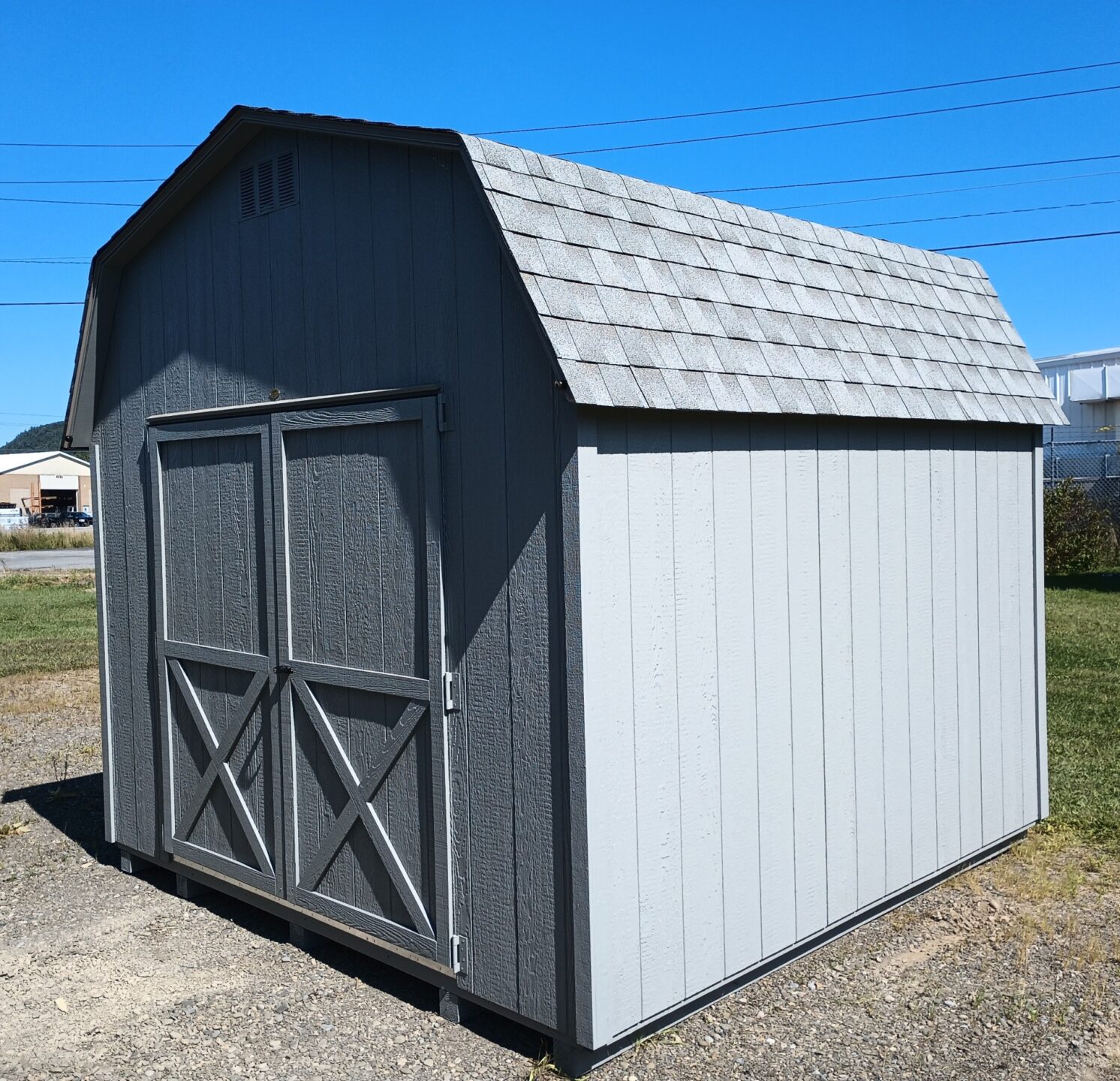 Barn style shed with shingled roof and double door